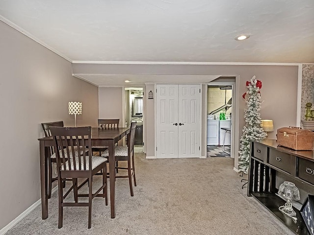 dining area with washer / dryer, crown molding, and light carpet