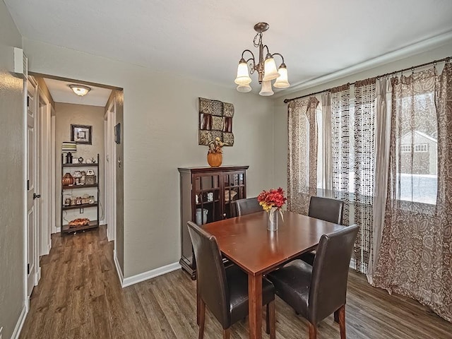 dining space with a chandelier and dark wood-type flooring