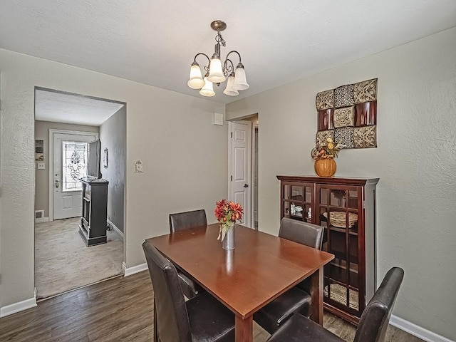 dining room with a notable chandelier and dark hardwood / wood-style floors