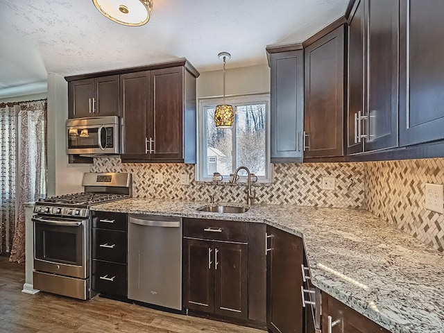 kitchen with stainless steel appliances, dark brown cabinetry, sink, and dark hardwood / wood-style floors