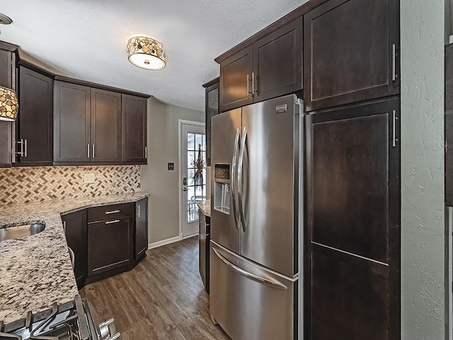 kitchen featuring dark hardwood / wood-style flooring, light stone counters, stainless steel refrigerator with ice dispenser, dark brown cabinetry, and tasteful backsplash