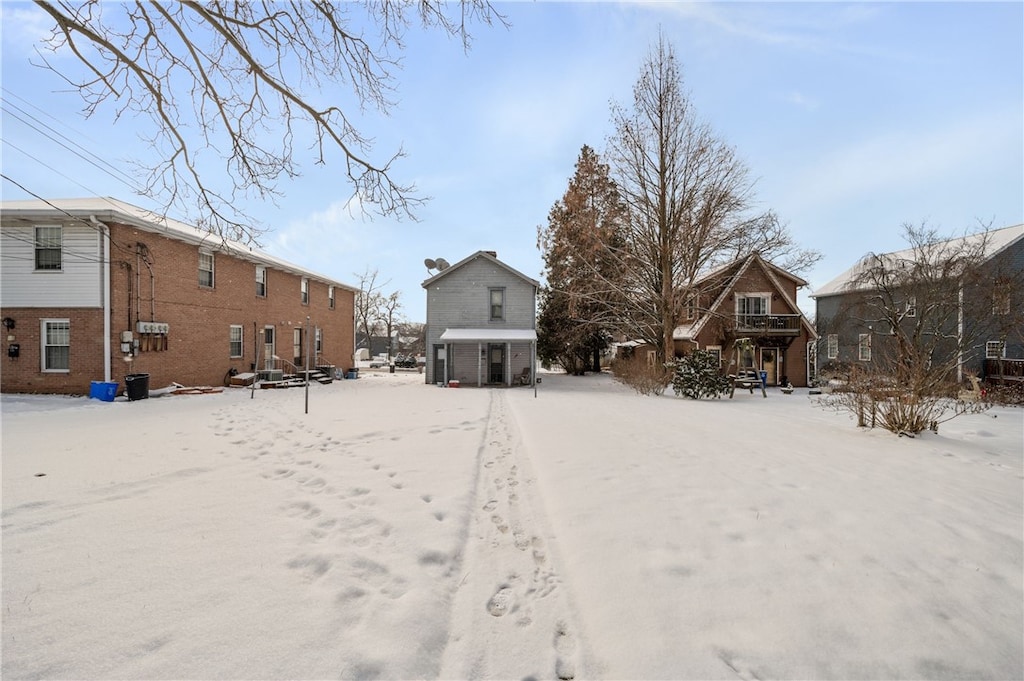 view of snow covered rear of property