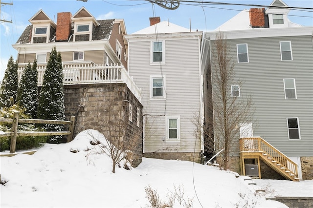 view of snow covered back of property