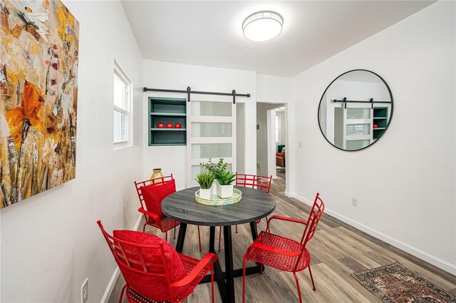 dining space featuring a barn door and hardwood / wood-style floors