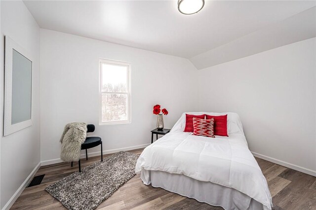 bedroom featuring vaulted ceiling and wood-type flooring