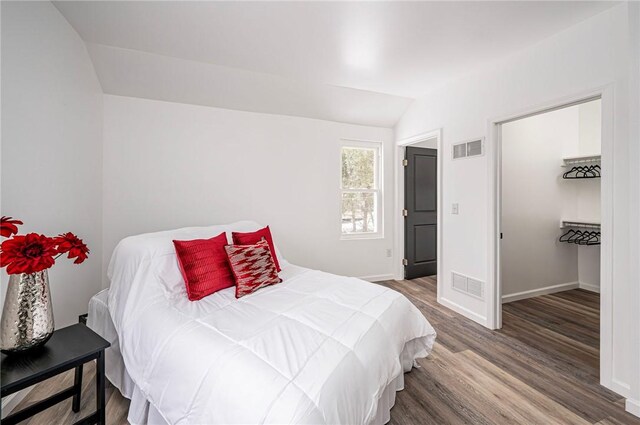 bedroom with vaulted ceiling and wood-type flooring