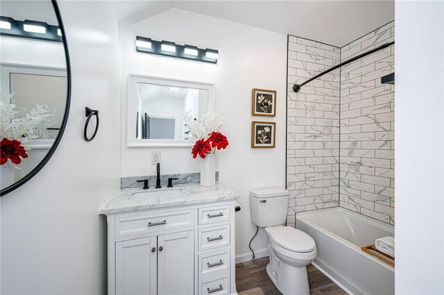 full bathroom with toilet, vanity, hardwood / wood-style floors, and tiled shower / bath