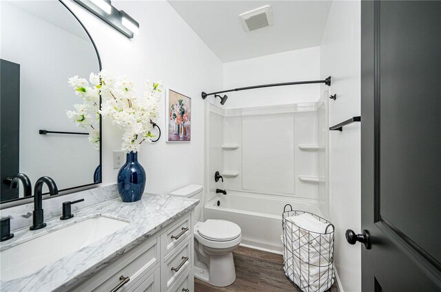 full bathroom with shower / washtub combination, toilet, vanity, and hardwood / wood-style flooring