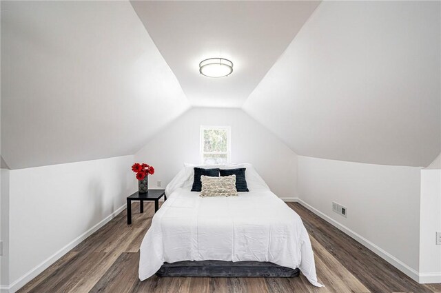 bedroom with dark hardwood / wood-style flooring and vaulted ceiling