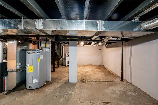 basement featuring electric water heater and heating unit