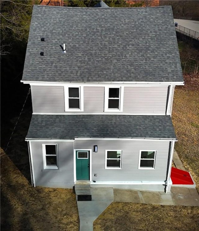 view of front facade with a shingled roof and entry steps