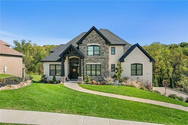 french country inspired facade featuring a front yard