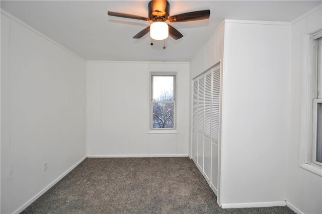 unfurnished bedroom featuring dark carpet, a closet, and ceiling fan