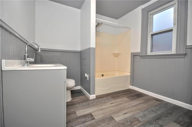 full bathroom with toilet, wood-type flooring, vanity, and bathtub / shower combination