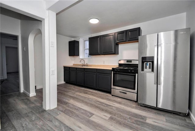 kitchen featuring stainless steel appliances, wood-type flooring, and sink