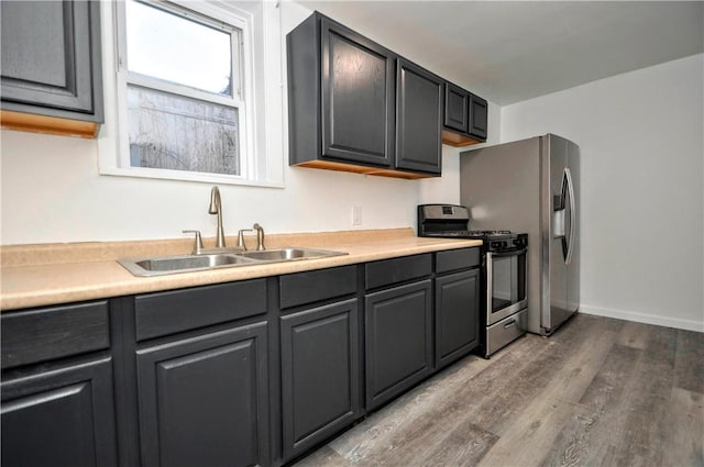 kitchen with sink, hardwood / wood-style flooring, gray cabinetry, and appliances with stainless steel finishes