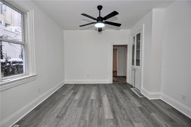 spare room with dark wood-type flooring and ceiling fan