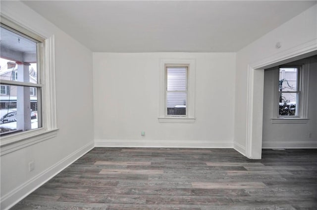 empty room featuring dark hardwood / wood-style flooring and plenty of natural light