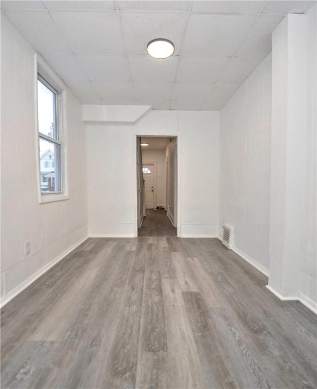 unfurnished room with a paneled ceiling and dark hardwood / wood-style floors