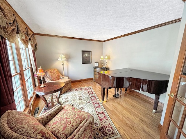 living area featuring a textured ceiling, ornamental molding, and light hardwood / wood-style flooring