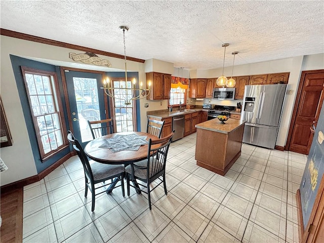 kitchen with sink, pendant lighting, appliances with stainless steel finishes, and a kitchen island