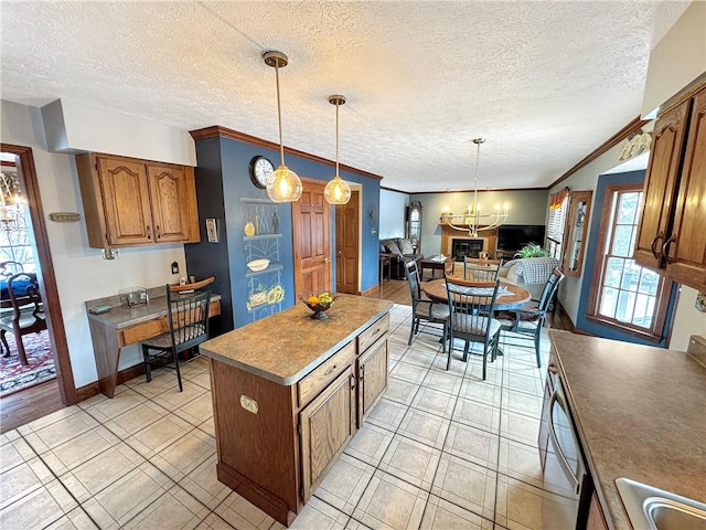 kitchen with ornamental molding, a textured ceiling, a chandelier, pendant lighting, and a center island