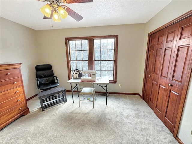 sitting room featuring ceiling fan, light colored carpet, and a textured ceiling