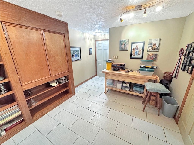 office space featuring a textured ceiling and light tile patterned flooring