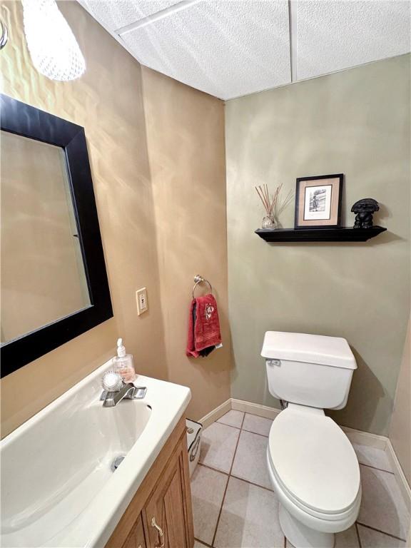 bathroom with toilet, tile patterned flooring, and vanity