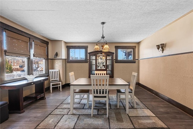 dining area featuring a textured ceiling and dark hardwood / wood-style floors