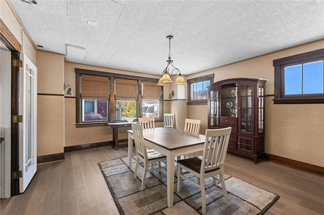 dining room featuring a textured ceiling, crown molding, and wood-type flooring