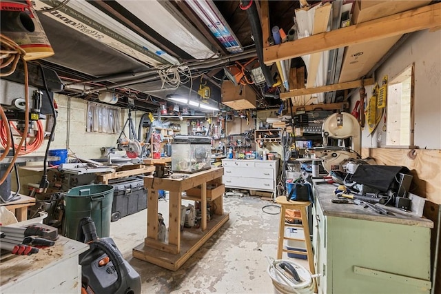 miscellaneous room with concrete flooring and a workshop area