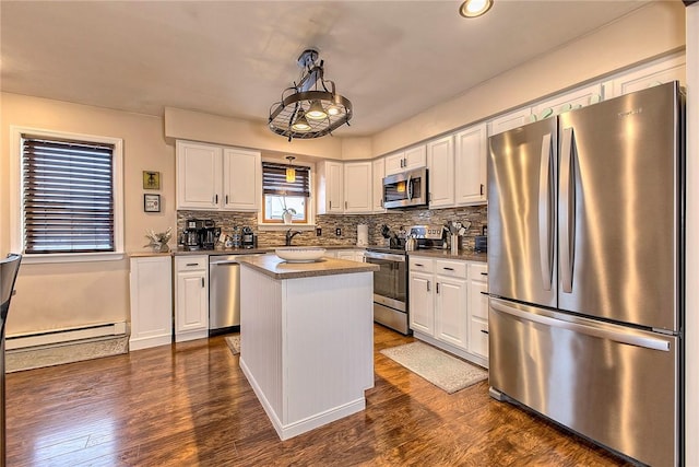 kitchen featuring stainless steel appliances, white cabinetry, a center island, and baseboard heating