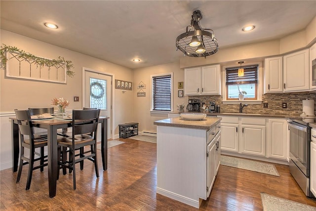 kitchen featuring a kitchen island, white cabinets, decorative backsplash, and appliances with stainless steel finishes