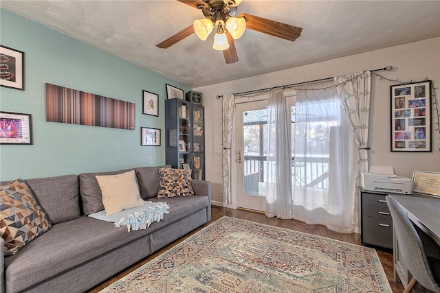 living room featuring wood-type flooring, a textured ceiling, and ceiling fan