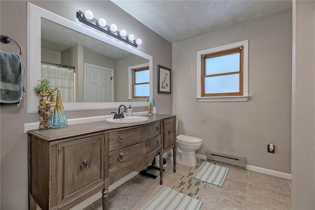 bathroom featuring baseboard heating, plenty of natural light, vanity, and toilet