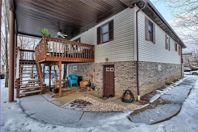 view of snow covered exterior featuring ceiling fan and a wooden deck