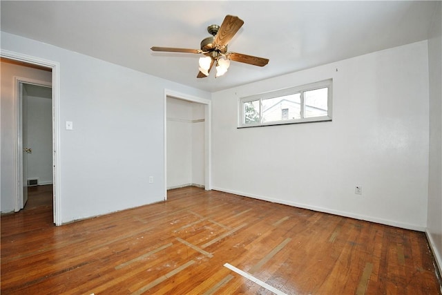 unfurnished bedroom featuring hardwood / wood-style floors, a closet, and ceiling fan