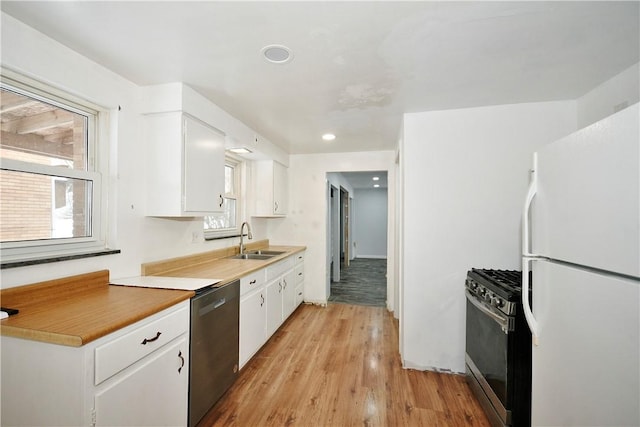 kitchen featuring sink, white cabinets, light hardwood / wood-style flooring, and appliances with stainless steel finishes