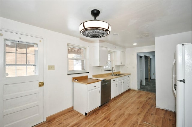 kitchen with stainless steel dishwasher, white fridge, light wood-type flooring, white cabinets, and sink