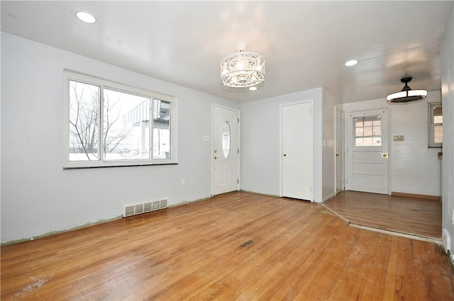 entrance foyer with an inviting chandelier and wood-type flooring