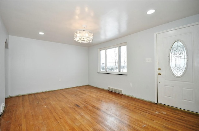 foyer featuring wood-type flooring and a chandelier