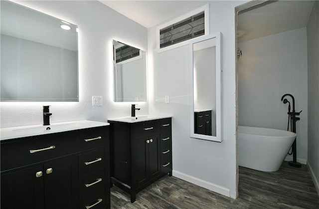 bathroom featuring a bath, vanity, and wood-type flooring