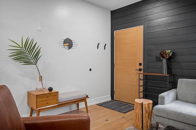 foyer entrance featuring hardwood / wood-style floors and wooden walls