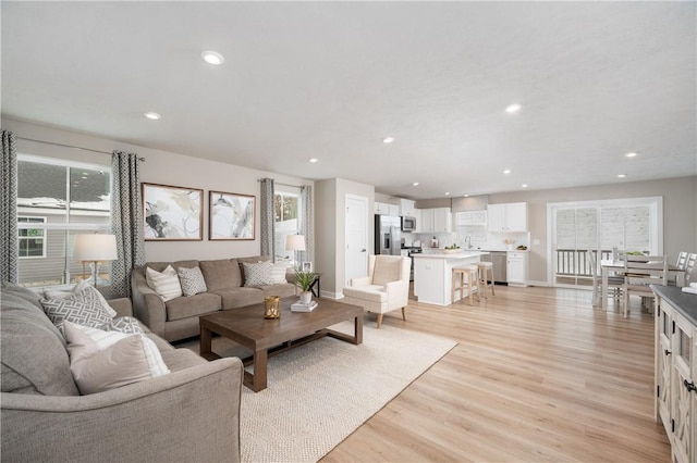 living room with light wood-type flooring and sink