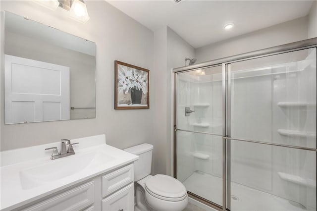 bathroom with an enclosed shower, vanity, and toilet