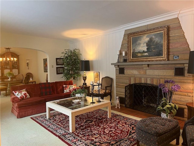 living room with a notable chandelier, ornamental molding, and a fireplace