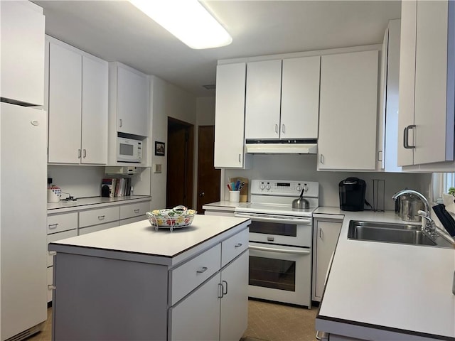 kitchen featuring white appliances, a kitchen island, white cabinetry, and sink