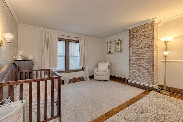 bedroom featuring wood-type flooring, ornamental molding, and a nursery area