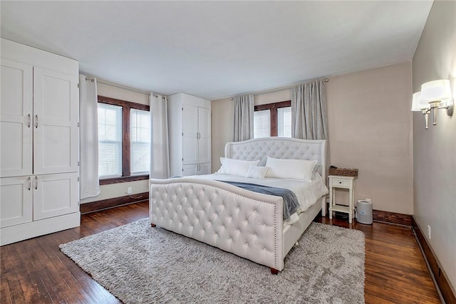 bedroom with dark wood-type flooring and multiple windows